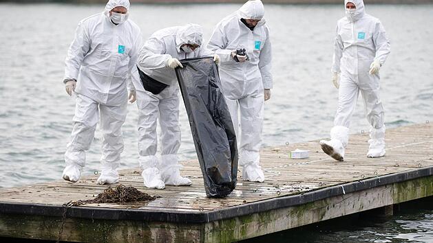 Polizisten begutachten am 01.11.2012 am Nordufer des Maschsees in Hannover (Niedersachsen) den Inhalt einer M&uuml;llt&uuml;te, welche zuvor von einem Polizeitaucher geborgen wurde. Nach dem Fund einer zerst&uuml;ckelten Prostituierten im Maschsee in Hannover hat die Polizei den mutma&szlig;lichen T&auml;ter gefasst. Foto: Emily Wabitsch/dpa (zu lni 1667 vom 29.11.2012