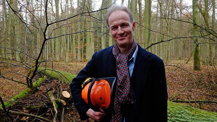Professor Boris Dreyer stolz mit Helm vor der gefällten Eiche  Foto: Nikolas Pelke