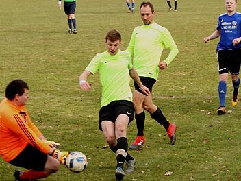 Augsfelds Torwart Michael Werner (links) schnappt noch dem Neuschleichacher Pascal Burgis (Zweiter von links) den Ball weg; dahinter der Neuschleichacher Spielertrainer Jonas Schmitt (rechts).