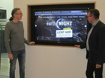 Am Großbild-Monitor im Rathaus-Remter werben Dr. Joachim Schneider (links) vom Naturerlebniszentrum Rhön und Bürgermeister Armin Warmuth für den Schutz der Nacht zur "Earth Night" am 7. September.