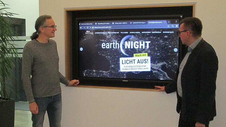 Am Großbild-Monitor im Rathaus-Remter werben Dr. Joachim Schneider (links) vom Naturerlebniszentrum Rhön und Bürgermeister Armin Warmuth für den Schutz der Nacht zur "Earth Night" am 7. September.