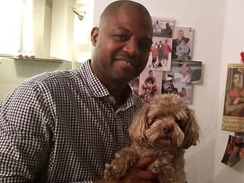 Familienmensch Taylor mit Hund Cookie, einem "Bolonka". Im Hintergrund Familienbilder und eine Autogrammkarte von Sohn David.  Foto: Glas