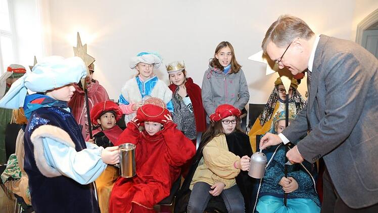 OB Andreas Starke steckt einige Scheine in die Büchsen der Sternsinger  aus der Pfarrei St. Martin. Barbara Herbst