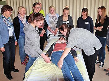 Eine junge Altenpflegeschülerin (Mitte liegend) demonstriert, wie das Umbetten von Senioren richtig funktioniert.  Fotos: Dieter Britz