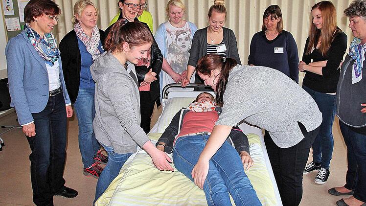Eine junge Altenpflegeschülerin (Mitte liegend) demonstriert, wie das Umbetten von Senioren richtig funktioniert.  Fotos: Dieter Britz