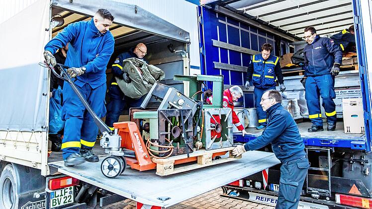 THW und BRK laden Hilfsg&uuml;ter zum weiteren Transport und zur Verteilung um. Der Kirchehrenbacher Helfer Thomas Albert (2.&nbsp;v.&nbsp;l.) hat sich ein Zelt zum Umladen geschnappt.