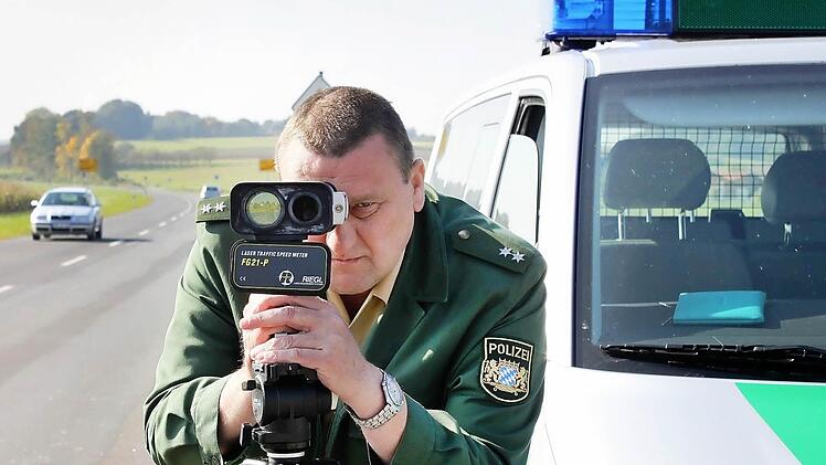 Sebastian Selig visiert mit der Laserpistole vorbeifahrende Autos an, die dann - sofern sie zu schnell sind - von einem Kollegen sofort angehalten und zur Rechenschaft gezogen werden.   Foto: Andreas Dorsch/Archiv