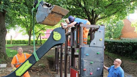 Klaus Schebler (vorne rechts), Stefan Sluzar und Ulla Müller (hinten auf dem Gerüst) verfolgen den Aufbau des Kletterturms. Foto: Heike Beudert