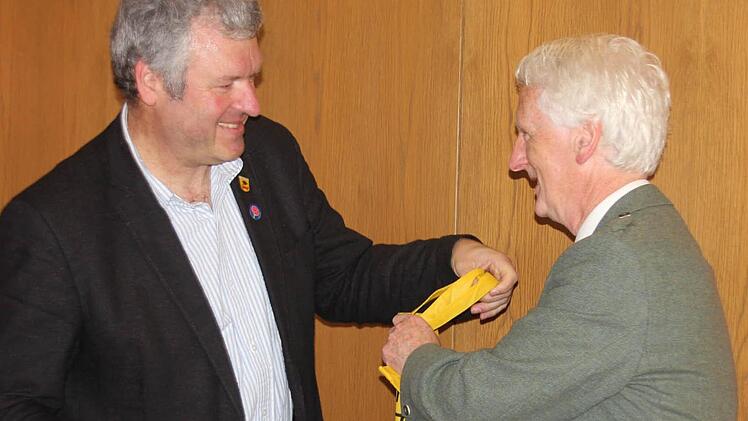 Bürgermeister Hennemann (links) überreichte dem Schulleiter Melvin Lynch ein Gastgeschenk.
