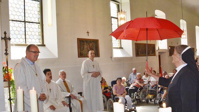 Damit Peter Schott immer gut von Gott beschirmt sein möge, überreichte Schwester Edith, Generaloberin aus Ursberg, einen Regen/Sonnenschirm. Foto: Friedrich