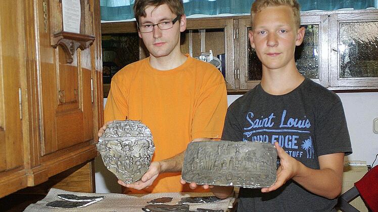 Der Hammelburger Küster Michael Brendan (links) und sein Praktikant Lukas Lange (rechts) sichten die Reliefabgüsse in der St. Johannes-Sakristei. Fotos: Winrfried Ehling