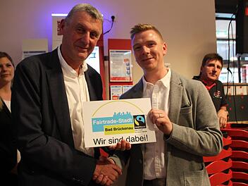 2. Bürgermeister Jürgen Pfister überreicht Sebastian Hauke das Schild. Es weist darauf hin, dass im neuen Markt Produkte aus fairem Handel angeboten werden. Foto: Ulrike Müller