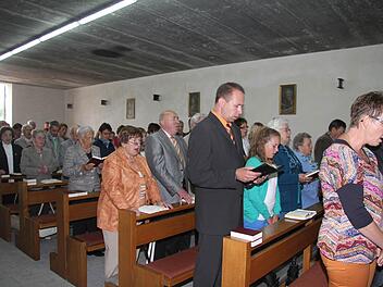 Das alte Fabrikgebäude in Wartenfels ist mit den Bänken der St.-Bartholmäus-Kirche ausgestattet. An der Wand hängen Bilder der Evangelisten, und sogar das Allerheiligste und ein ausgeleuchtetes Kreuz gehören zum Interieur. Eine Orgel sowieso. Fotos: Sonja Adam