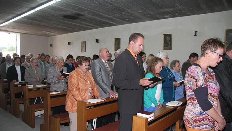 Das alte Fabrikgebäude in Wartenfels ist mit den Bänken der St.-Bartholmäus-Kirche ausgestattet. An der Wand hängen Bilder der Evangelisten, und sogar das Allerheiligste und ein ausgeleuchtetes Kreuz gehören zum Interieur. Eine Orgel sowieso. Fotos: Sonja Adam