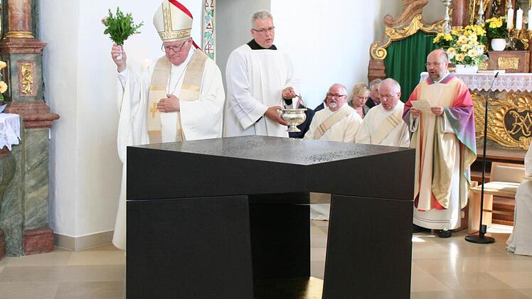 Weihbischof Werner Radspieler besprengt den neuen Altar mit Weihwasser.
