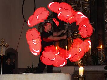 Mit seinem "akrobatischen Beamer" erzeugte Matthias Ebert Worte und Symbole rund um das Thema Liebe in der dunklen Pfarrkirche in Knetzgau.  Foto: Christiane Reuther
