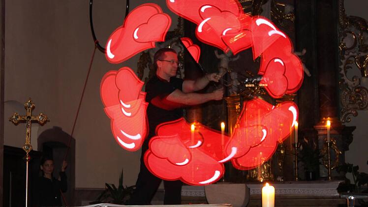 Mit seinem "akrobatischen Beamer" erzeugte Matthias Ebert Worte und Symbole rund um das Thema Liebe in der dunklen Pfarrkirche in Knetzgau.  Foto: Christiane Reuther