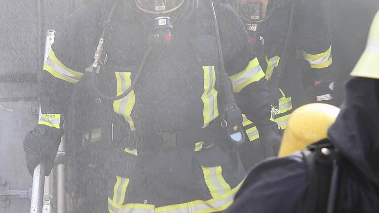 Kühlen Kopf bewahrt und dennoch verdampft Wasser auf den heißen Helmen der Feuerwehrleute.