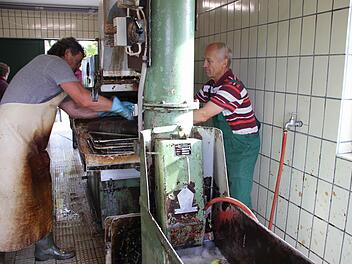 Hans-Jürgen Herzig (links)  und Heinz Spindler quetschen die Äpfel aus heimischen Gärten aus. Foto: Ralf Kestel