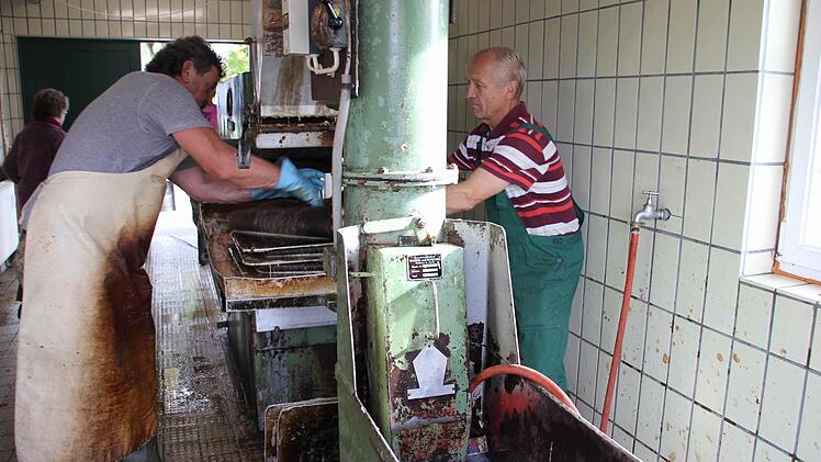 Hans-Jürgen Herzig (links)  und Heinz Spindler quetschen die Äpfel aus heimischen Gärten aus. Foto: Ralf Kestel