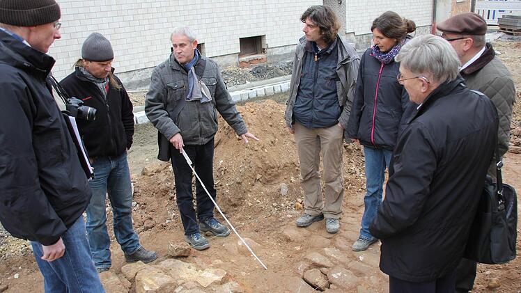 Bauamtleiter Martin Lang, Vorarbeiter Matthias Häfner, Planer Winfried Lamberty, die Archäologen Reiner Burkard und Anke Köber, Bürgermeister Robert Herrmann und Kreisheimatpfleger Günter Lipp beim Besichtigen der Fundstelle