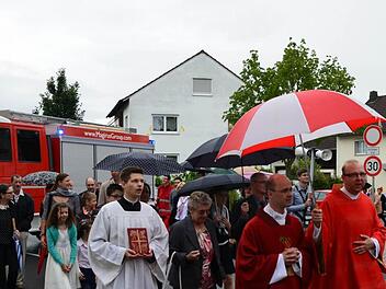 Ihren neuen Priester Daniel Bittel (Zweiter von rechts) geleiteten die Strullendorfer in einem großen Zug zur Kirche. Foto: Andrea Spörlein
