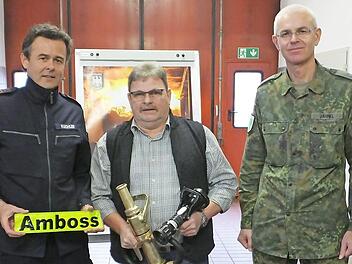Der Leiter der Bundeswehrfeuerwache, Frank Kuchler (links) und Oberstleutnant Roman Jähnel, Kommandeur Truppenübungsplatzverbund Süd (rechts) dankten Klaus-Dieter Henkel zum Abschied. Foto: Edgar Maier