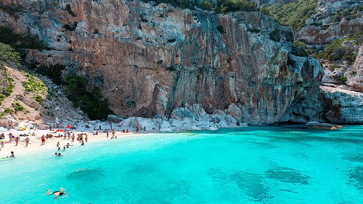 Cala Gonone, Sardinien, Italien, Cala Mariolu – Wunderschöner Strand voller Sonnenschirme und Menschen, die sich sonnen und im türkisfarbenen Wasser schwimmen Cala Gonone, Sardinien, Italien, Cala Mariolu – Wunderschöner Strand voller Sonnenschirme und Menschen, die sich sonnen und im türkisfarbenen Wasser schwimmen Cala Gonone, Sardinia, Italy, Cala Mariolu - Beautiful beach full of umbrellas and people sunbathing and swimming on a turquoise water Cala Gonone, Sardinia, Italy, Cala Mariolu - Beautiful beach full of umbrellas and people sunbathing and swimming on a turquoise water