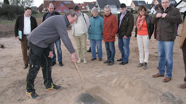 Grabungsleiter Magnus Wintergerst erklärt eines Löcher, in dem die Archäologen fündig wurden.