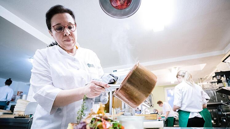 Zum Schluss die Soße: Chefköchin Barbara Detsch macht einen Teller servierfertig. Foto: Marian Hamacher