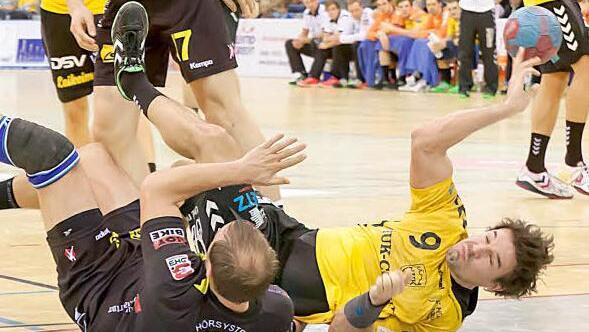 Unsanft gelandet: Nicht nur Kreisläufer Dominik Kelm (gelbes Trikot) erlitt eine Bruchlandung. Der HSC 2000 Coburg verlor sein zweites Saisonspiel und hat jetzt vier Punkte Rückstand auf den HSC Bad Neustadt.