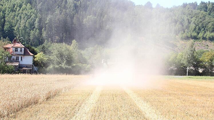In der dichten Staubwolke ist der Mähdrescher fast nicht zu erkennen.  Foto: Friedwald Schedel