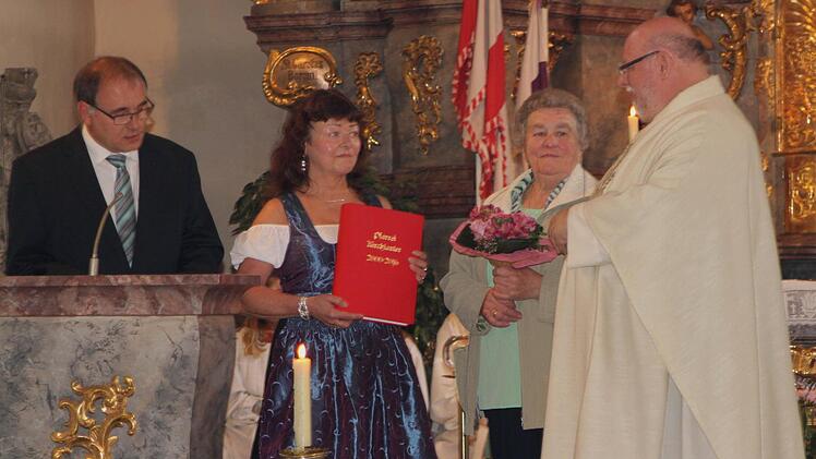 Pfarrgemeinderatsvorsitzender Robert Muckelbauer und Kirchenpflegerin Marieanne Baum (von links) bei der Verabschiedung von Pfarrer Martin Wissel (rechts); daneben seine Mutter. Fotos: Günther Geiling