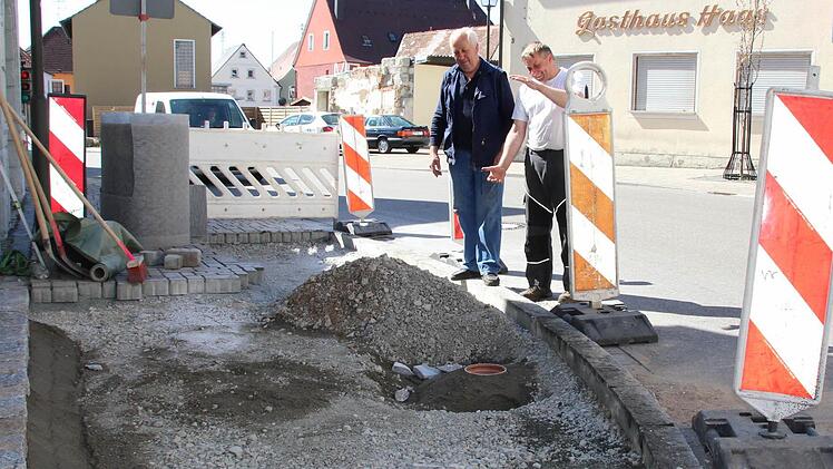 Die Anwohner Fritz Popp und Jürgen Tränkenschuh (von links) inspizieren die Baustelle in der Bamberger Straße, wo die verölten Pflastersteine und der darunter liegende Sand und Schotter ausgetauscht werden. Ein Poller hatte an dieser Stelle vor einem Jahr den Unfall ausgelöst. Das Hindernis auf dem Gehweg soll den Dachvorsprung des dort stehenden Hauses vor die Kurve schneidenden Lastwagen schützen.  Foto: Andreas Dorsch