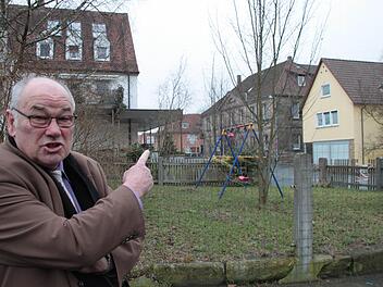 So nicht! Bürgermeister Dieter Adam zeigt auf den Bereich hinter sich. Dort, auf dem Grundstück Hauptstraße 31 direkt an der Kreuzung Konrad-Popp-Platz/Willmersreuther Straße, soll eine Plakatwerbetafel errichtet werden. Adam will das verhindern - notfalls vor Gericht. Foto: Jürgen Gärtner