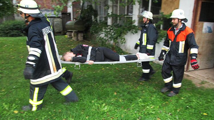 Feuerwehrleute retten die verängstigten Verwundeten, die sich in die ehemalige Schreinerei flüchteten.                Foto: Winfried Ehling