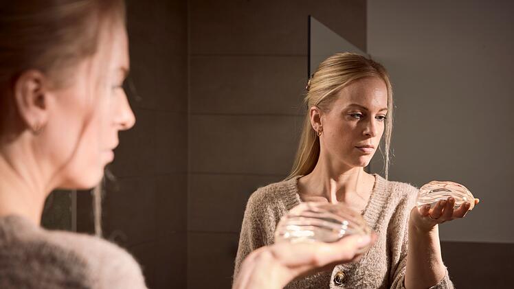 Lauren (36) hält nach zehn Jahren das Implantat in der Hand, das sie lange sehr krank gemacht hatte.