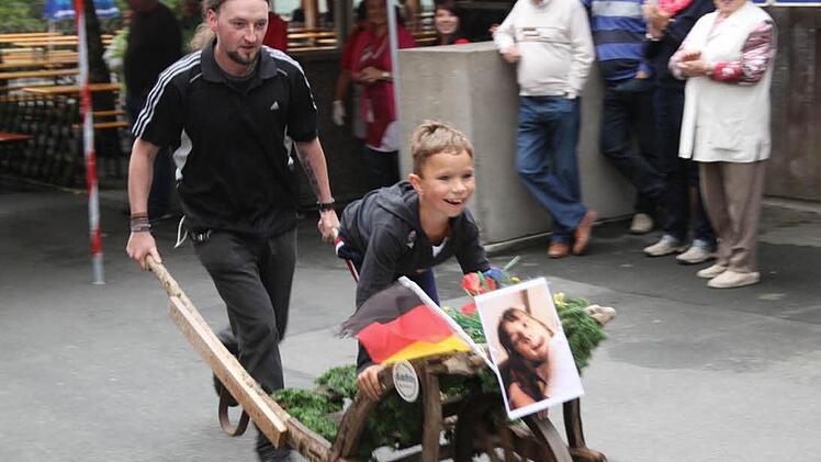 Der jüngste Teilnehmer (auf dem Schubkarren) beim Rennen rund um Heckenhof war Roben Baumann, geschoben von Alexander Bogner. Das Duo belegte zwar den letzten Platz, hatte aber riesig Spaß.  Fotos: Georg Wolf