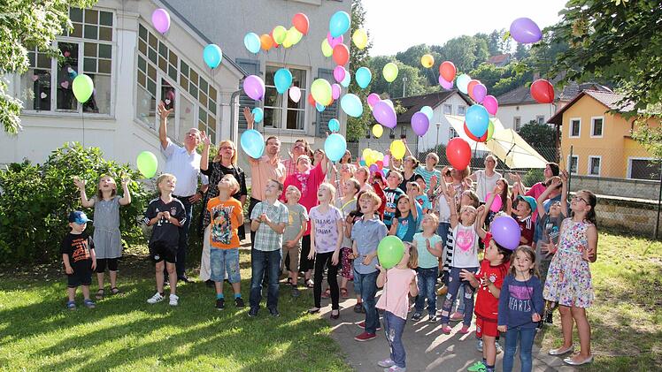 Die Kinder, ihre Erzieherinnen und Caritasvorsitzender Bernhard Müller, sein Stellvertreter Björn Kleyhauer, Kronachs 3. Bürgermeister Markus Wich, pädagogische Leiterin Irene Piontek und Hortleiterin Silke Leidner ließen Luftballons steigen. Foto: Rainer Glissnik