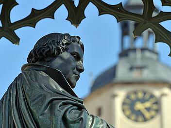 Vor dem Turm der Stadtkirche ist  die Statue des Reformators Martin Luther am Marktplatz in Wittenberg (Sachsen-Anhalt) zu sehen. Schmidt/dpa