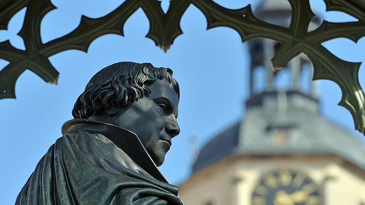 Vor dem Turm der Stadtkirche ist  die Statue des Reformators Martin Luther am Marktplatz in Wittenberg (Sachsen-Anhalt) zu sehen. Schmidt/dpa