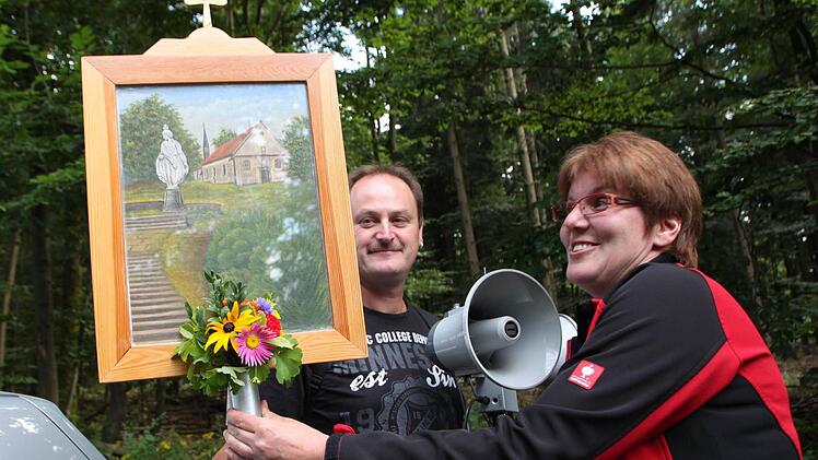 Mit geschickten Handgriffen befestigt Anja Perleth den Strauß am Wallfahrts-Bild. Fotos: Ulrike Müller