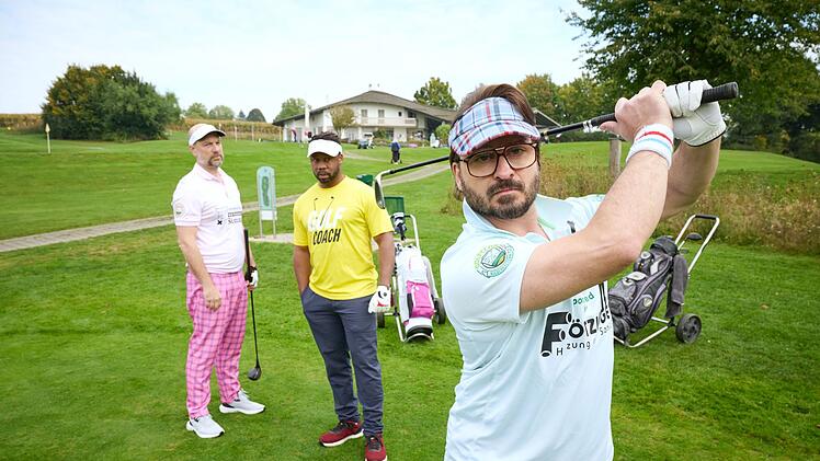 Simmerl (Stephan Zinner, l.) und Fl&ouml;tzinger (Daniel Christensen, r.) versuchen sich unter Aufsicht von Golflehrer Buengo (Castro Dokyi Affum) auf dem Gr&uuml;n.