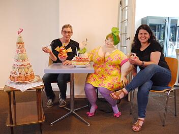 Museumsleiter Udo Leidner-Haber und Museumspädagogin Alexandra Taschner bereiten eine Sonderausstellung vor. Für das Foto haben sie sich zu Künstlerpuppe Emma gesellt, die es sich mit Eis und Kuchen gutgehen lässt. Foto: Rebecca Vogt