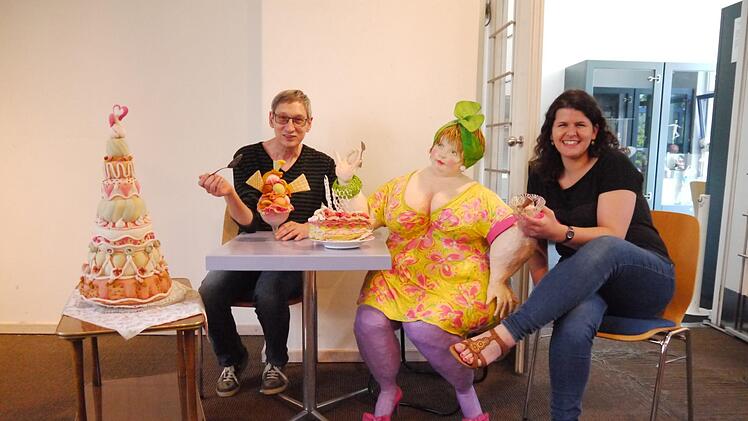 Museumsleiter Udo Leidner-Haber und Museumspädagogin Alexandra Taschner bereiten eine Sonderausstellung vor. Für das Foto haben sie sich zu Künstlerpuppe Emma gesellt, die es sich mit Eis und Kuchen gutgehen lässt. Foto: Rebecca Vogt