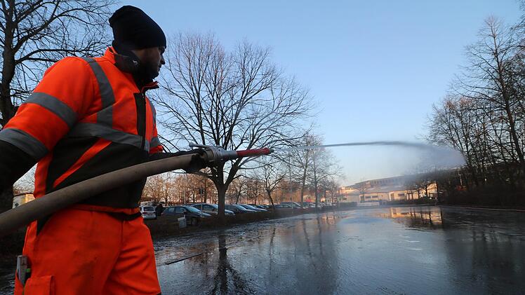 Ein Mitarbeiter der Stadt bew&auml;sserte am Freitagnachmittag den Parkplatz vor dem K&ouml;nigsbad.  Sobald das Wasser gefroren ist, k&ouml;nnen die Forchheimer dort Eislaufen. Foto: Ronald Heck