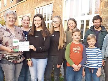 Von links: Günther Scheler, Sabine Scherbel (AK Familie), Evi Scheler, Natascha Christmann (Struwwel), Sophia Wagner, Emma Schneider, Nicole Backer (AK Familie), Geschwister Backer, Samuel Rauch, Kristina Fritz (Struwwel), Emma Christmann und 2. Bürgermeisterin Angela Hofmann freuen sich über die Spende des Mädchen-Cafés. Foto: Heike Schülein