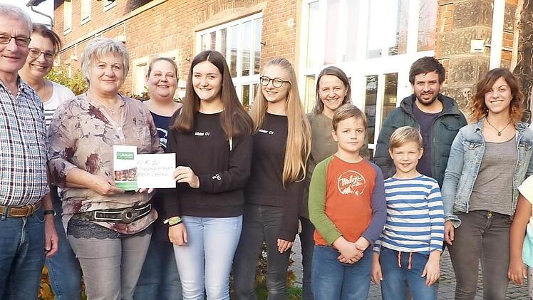 Von links: Günther Scheler, Sabine Scherbel (AK Familie), Evi Scheler, Natascha Christmann (Struwwel), Sophia Wagner, Emma Schneider, Nicole Backer (AK Familie), Geschwister Backer, Samuel Rauch, Kristina Fritz (Struwwel), Emma Christmann und 2. Bürgermeisterin Angela Hofmann freuen sich über die Spende des Mädchen-Cafés. Foto: Heike Schülein