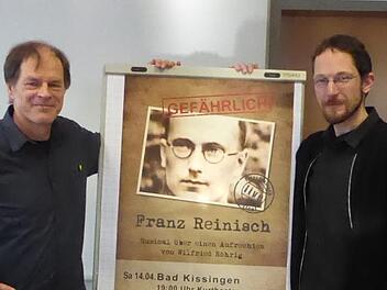 Komponist und Texter Wilfried Röhrig (links) und Hauptdarsteller Mathias Gall (rechts) vor dem Plakat des Pater-Reinisch-Musicals.  Foto: Thomas Ahnert