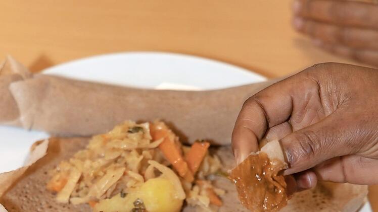 Katrin Ruppert war fasziniert von der Fingerfertigkeit von Hana und Amina (Bild oben). - Die schnippelten rasant Gem&uuml;se und formten mit ge&ouml;lten Fingern sekundenschell Sambusa (Bild rechts).  Fotos: Rudolf Hein